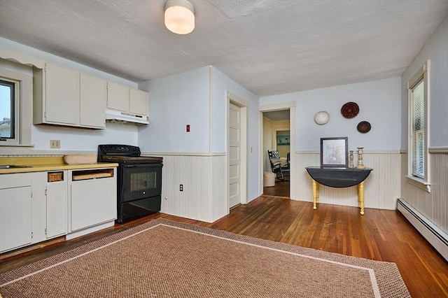 154 N Maple St, Northampton, MA 01062 - kitchen featuring black / electric stove, a baseboard radiator, under cabinet range hood, dark wood-type flooring, and wainscoting