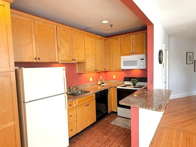 kitchen featuring white appliances, a sink, light stone countertops, recessed lighting, and baseboards