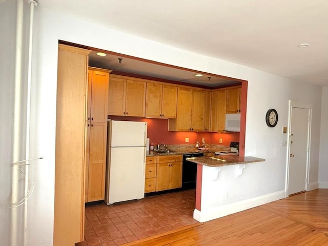 kitchen with white appliances, a peninsula, a breakfast bar area, recessed lighting, and baseboards