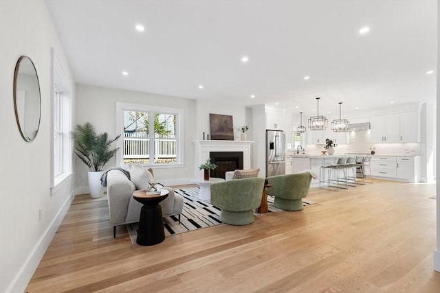 living room featuring sink and light hardwood / wood-style floors