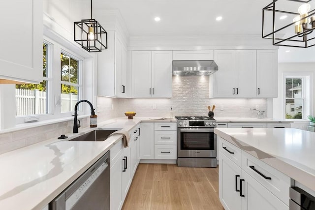 kitchen with white cabinetry, pendant lighting, wall chimney exhaust hood, and stainless steel appliances