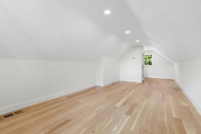 additional living space featuring lofted ceiling and light hardwood / wood-style flooring