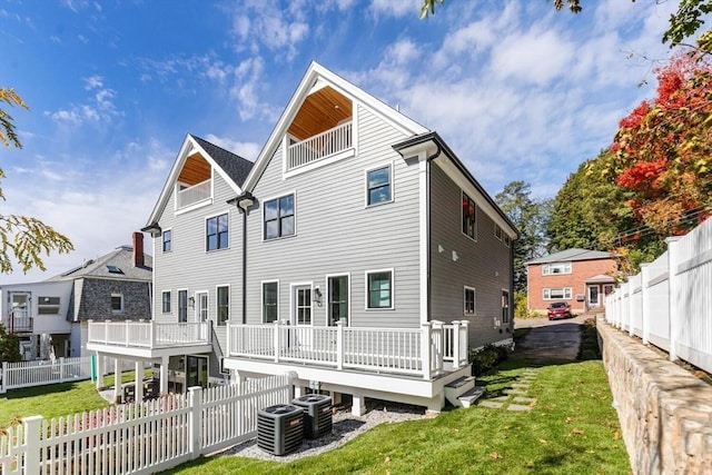 back of property featuring a lawn, a wooden deck, and central AC