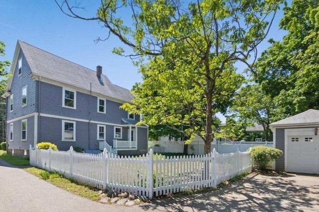 781 Highland Ave, Needham, MA 02494 - view of front facade with a chimney, a fenced front yard, a garage, and a shingled roof