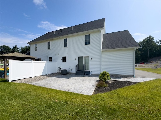 back of house featuring central air condition unit, a patio area, and a yard