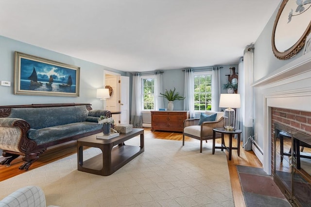 15 Thoreau Rd, Acton, MA 01720 - living area featuring a fireplace, light wood finished floors, a baseboard radiator, and a baseboard heating unit