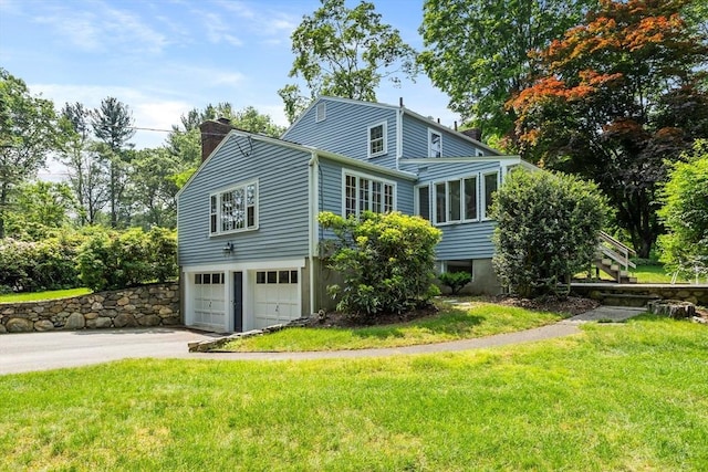 15 Thoreau Rd, Acton, MA 01720 - view of side of property with a chimney, driveway, a garage, a sunroom, and stairs
