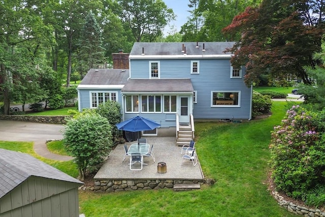 15 Thoreau Rd, Acton, MA 01720 - back of house featuring a patio, a chimney, a lawn, and roof with shingles