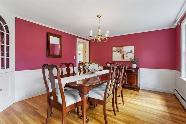 15 Thoreau Rd, Acton, MA 01720 - dining space with a chandelier, a baseboard radiator, light wood finished floors, a wainscoted wall, and ornamental molding