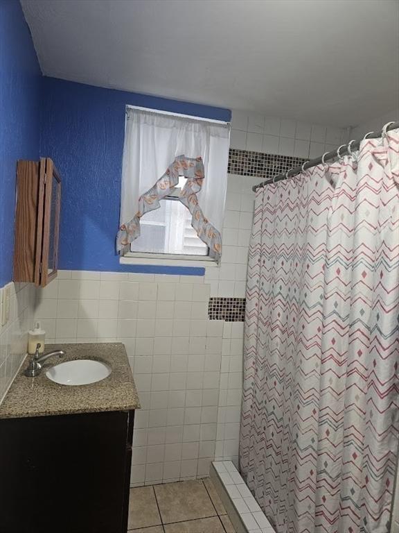 192 Chestnut St, Chelsea, MA 02150 - bathroom featuring vanity, curtained shower, tile walls, a textured wall, and tile patterned flooring