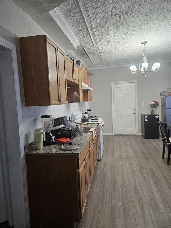 192 Chestnut St, Chelsea, MA 02150 - kitchen featuring white stove, an ornate ceiling, under cabinet range hood, light wood-type flooring, and a chandelier