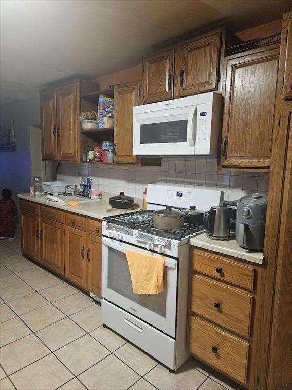 192 Chestnut St, Chelsea, MA 02150 - kitchen with white appliances, light tile patterned flooring, light countertops, and open shelves