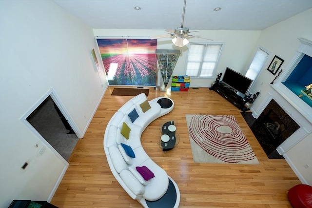 interior space with ceiling fan, a high end fireplace, and light hardwood / wood-style floors