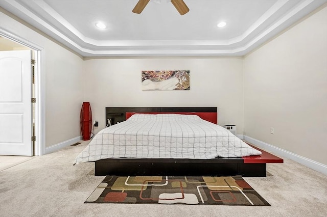 bedroom featuring carpet floors, ceiling fan, and a tray ceiling