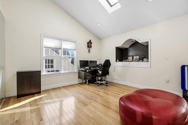 office area with hardwood / wood-style flooring, high vaulted ceiling, and a skylight