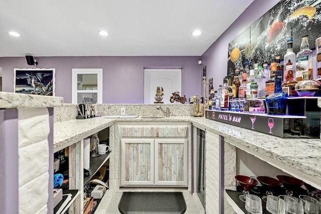 kitchen featuring light stone countertops and sink