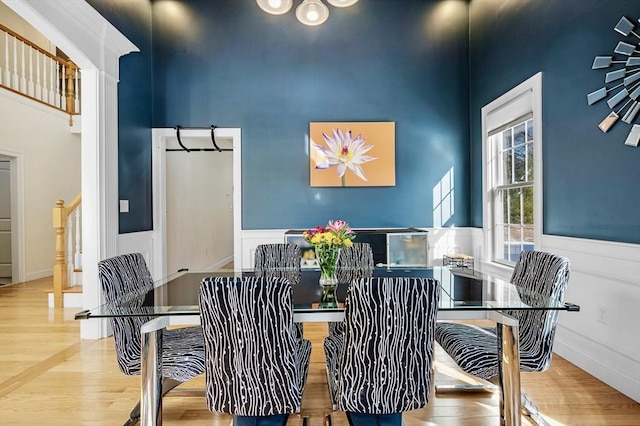 dining room featuring a towering ceiling and hardwood / wood-style floors