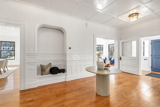 foyer with light wood-type flooring and coffered ceiling