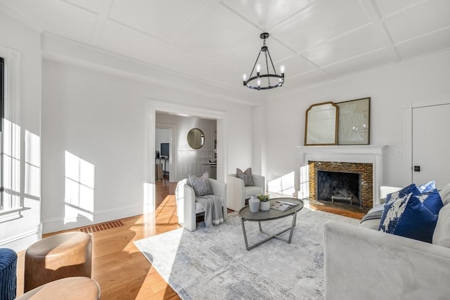 living room with a notable chandelier, wood-type flooring, and coffered ceiling