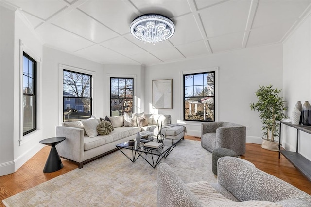 living room featuring a healthy amount of sunlight, wood-type flooring, and coffered ceiling