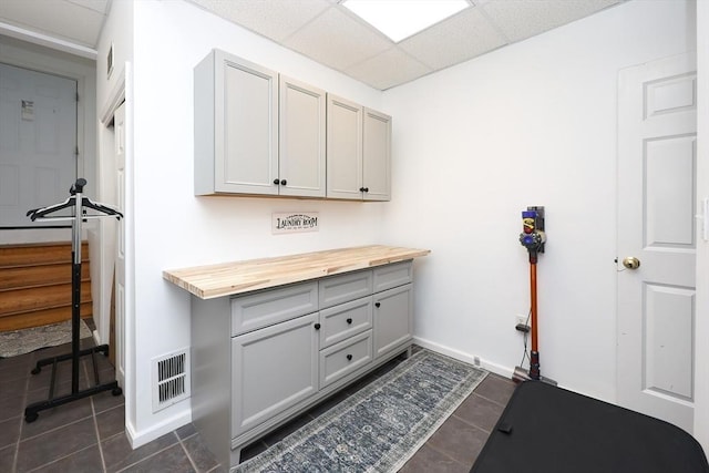 laundry area with dark tile patterned flooring