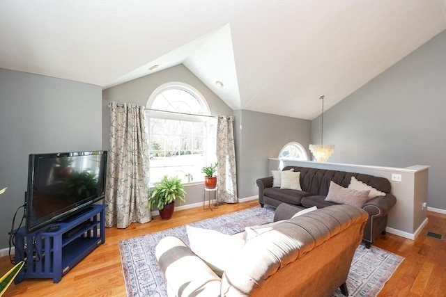 living room with wood-type flooring and vaulted ceiling