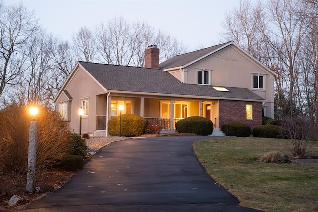 view of front of house featuring covered porch and a lawn