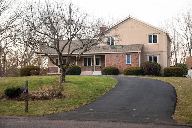 front facade with a porch and a front lawn