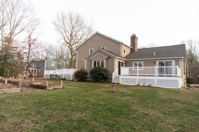 rear view of property featuring a wooden deck and a yard