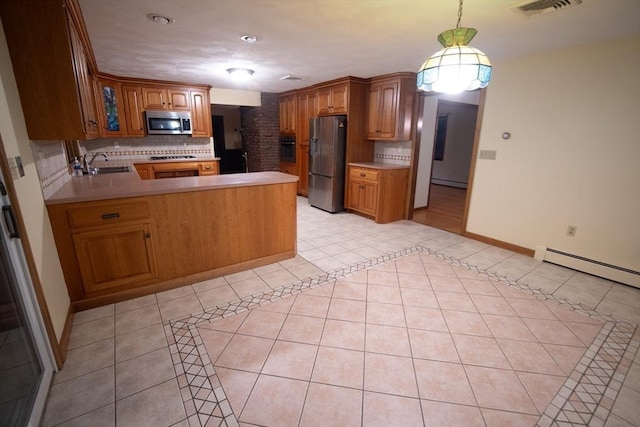 kitchen featuring sink, hanging light fixtures, tasteful backsplash, kitchen peninsula, and appliances with stainless steel finishes