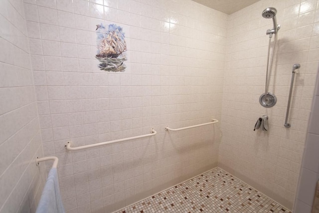 bathroom featuring tile patterned flooring and tiled shower