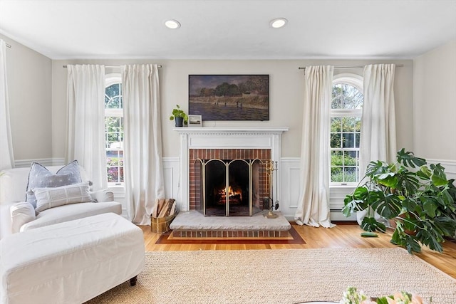38 Thoreau Cir, Beverly, MA 01915 - sitting room featuring a brick fireplace, wood finished floors, wainscoting, recessed lighting, and a decorative wall