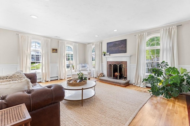 38 Thoreau Cir, Beverly, MA 01915 - living area featuring healthy amount of natural light, a wainscoted wall, a fireplace, a decorative wall, and wood finished floors
