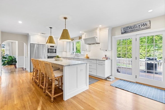 38 Thoreau Cir, Beverly, MA 01915 - kitchen with high quality fridge, a center island, light wood-type flooring, white cabinetry, and a breakfast bar area