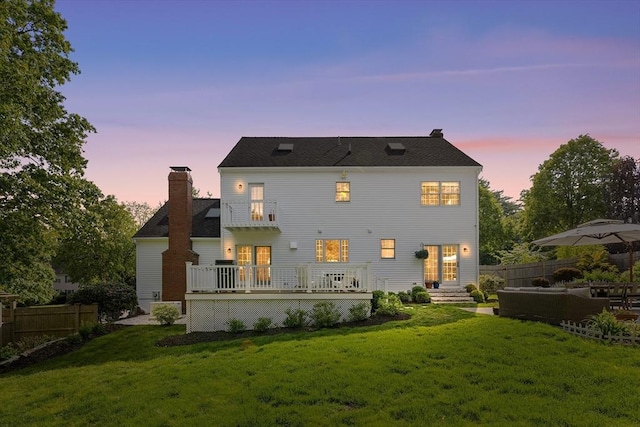 38 Thoreau Cir, Beverly, MA 01915 - back of property at dusk featuring a chimney and a wooden deck