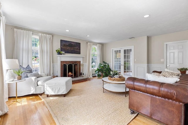 38 Thoreau Cir, Beverly, MA 01915 - living area featuring light wood finished floors, a brick fireplace, wainscoting, a decorative wall, and recessed lighting