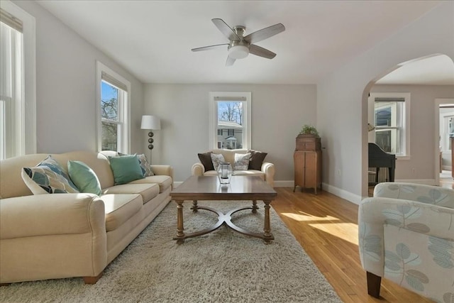 living room featuring plenty of natural light, ceiling fan, and light hardwood / wood-style flooring