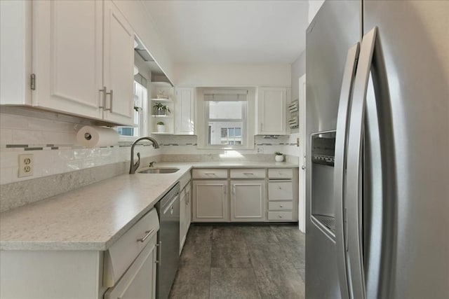 kitchen with stainless steel appliances, sink, decorative backsplash, and white cabinets