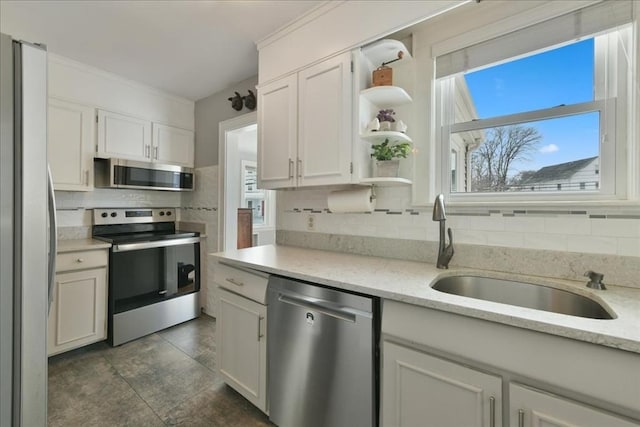 kitchen with tasteful backsplash, stainless steel appliances, sink, and white cabinets