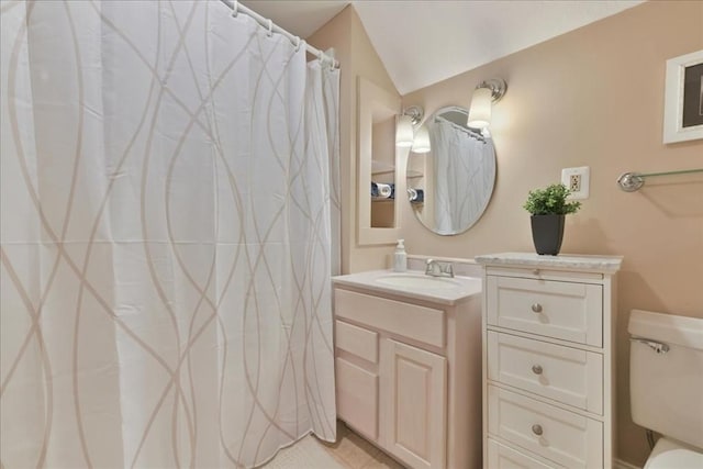 bathroom with vanity, toilet, and vaulted ceiling