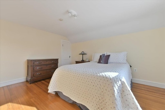 bedroom featuring lofted ceiling and light hardwood / wood-style floors