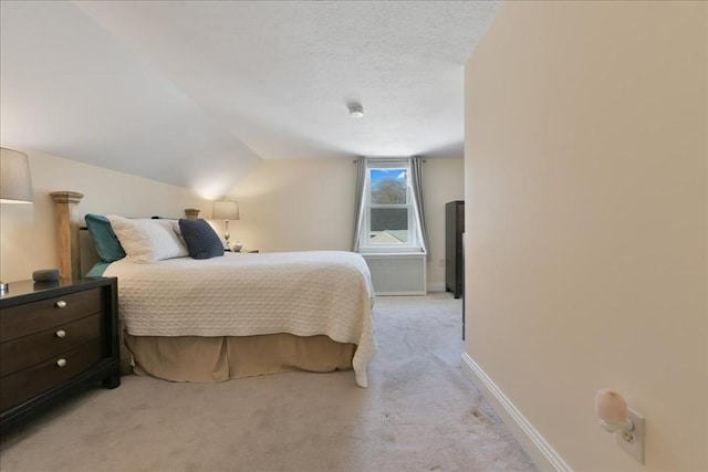 carpeted bedroom featuring lofted ceiling and a textured ceiling