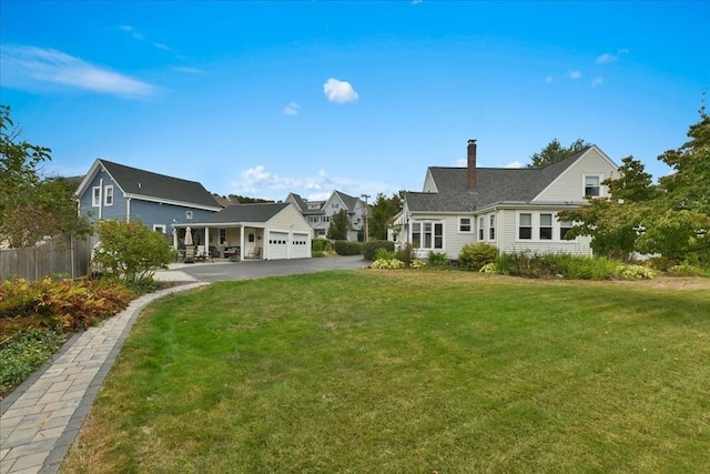 back of property featuring a garage and a yard