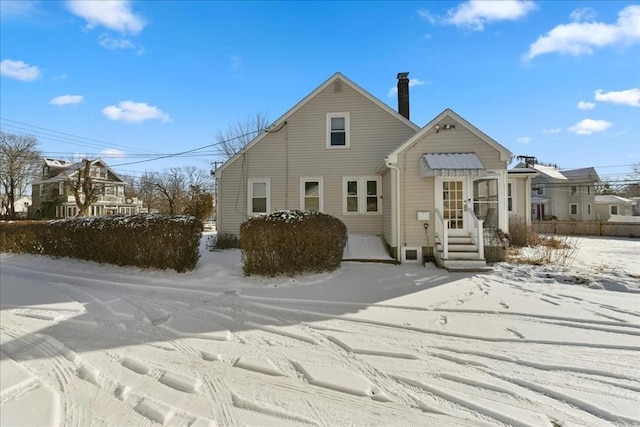 view of snow covered back of property