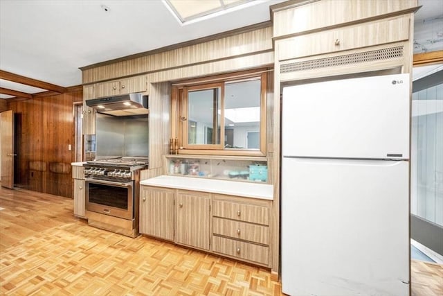 124 Mount Vernon Rd W, Weymouth, MA 02189 - kitchen featuring freestanding refrigerator, stainless steel range, under cabinet range hood, light countertops, and wooden walls