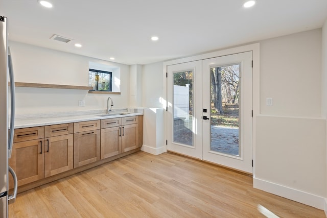 kitchen with a healthy amount of sunlight, sink, and french doors