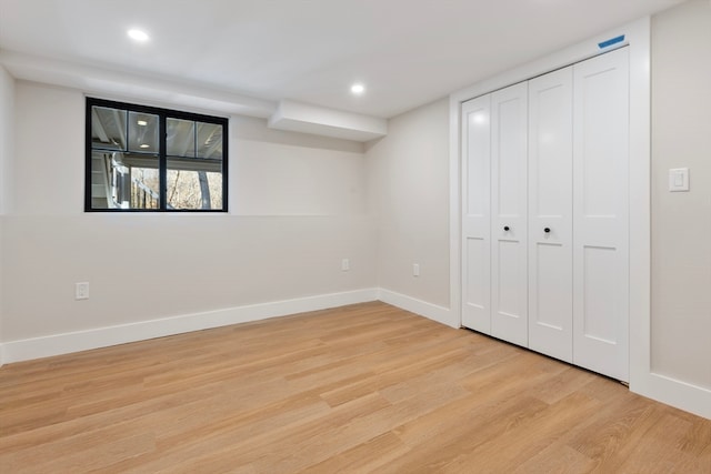 unfurnished bedroom with light wood-type flooring and a closet