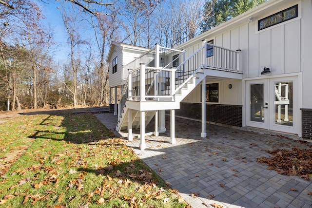 view of side of property with a deck, a patio, and french doors