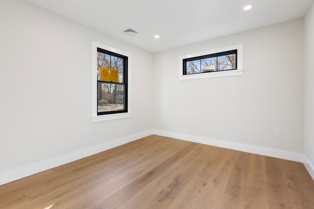 empty room with hardwood / wood-style flooring and a wealth of natural light