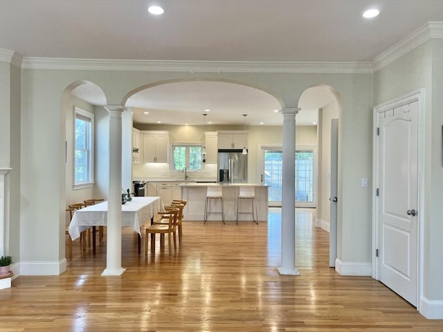 141 Pearl St Unit 141, Newton, MA 02458 - dining space featuring arched walkways, light wood-type flooring, healthy amount of natural light, recessed lighting, and crown molding